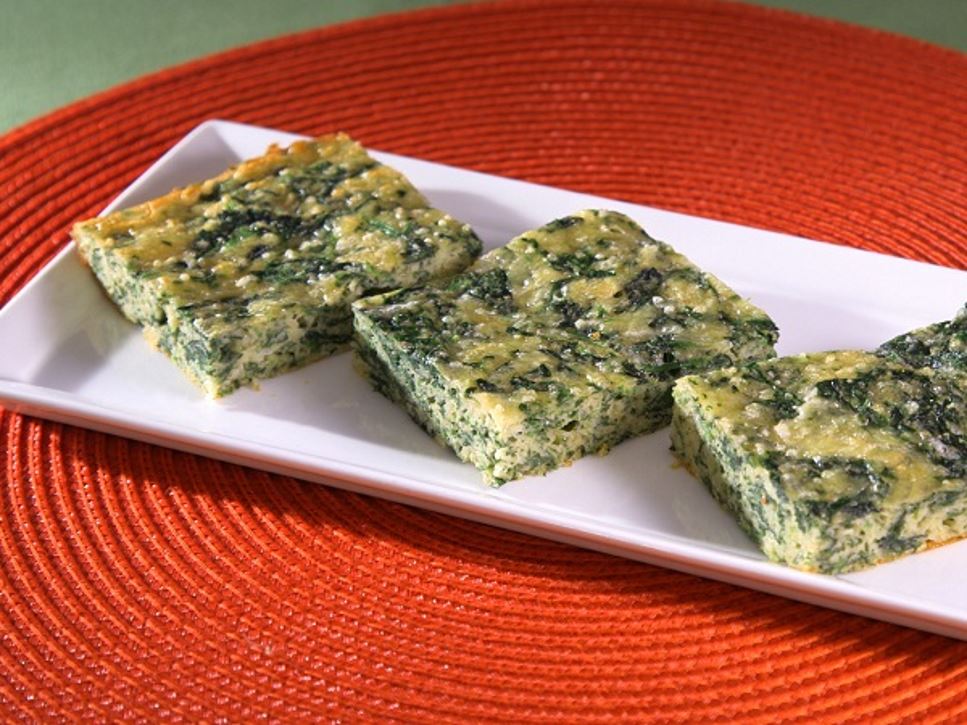 A rectangular white plate holding three parmesan spinach squares