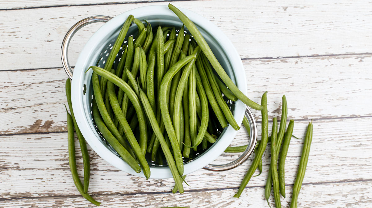 Fresh green beans in a colander.