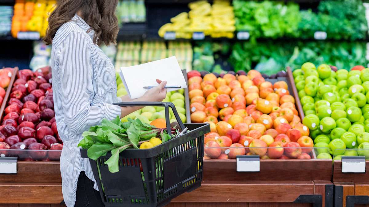 An adult shops for produce at the grocery store.
