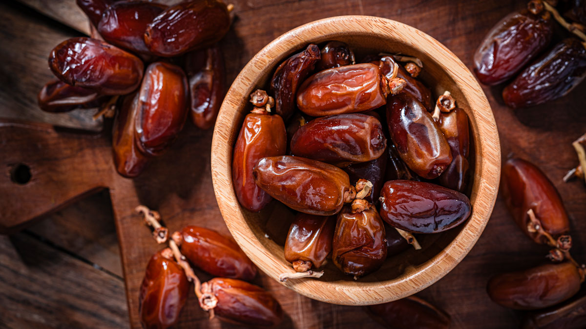 A small wooden bowl filled with dates.