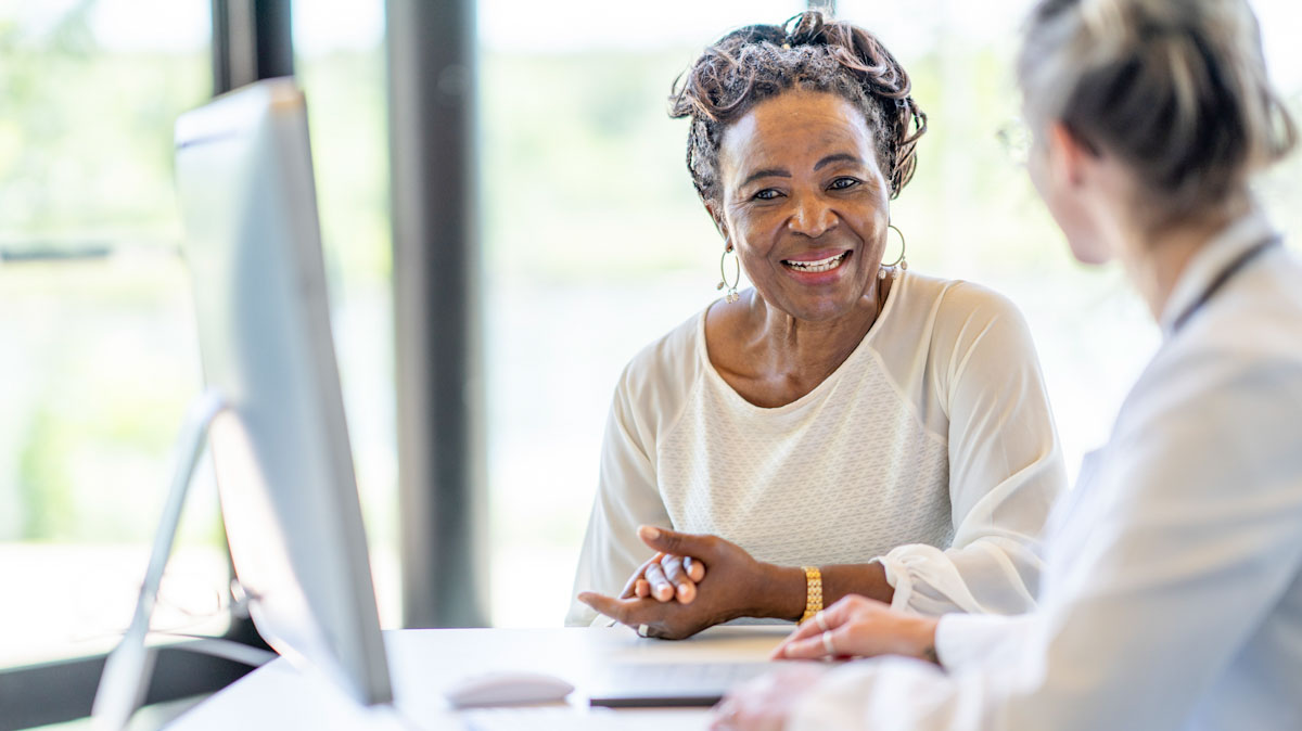 An older patient sits with a registered dietitian nutritionist at an office visit.