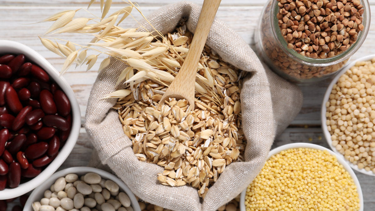 Containers of dried beans and whole grains sit on a table.