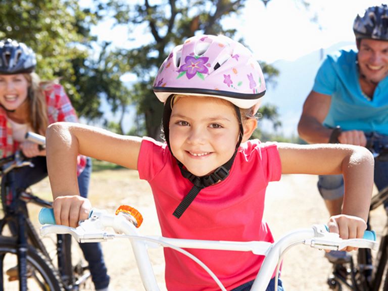 Girl riding bikes with her parents - 19 Easy Ways to Encourage Your Kids to Get Active