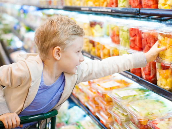 Boy reaching for fruit - Looking to Reduce Your Family's Added Sugar Intake? Here's How