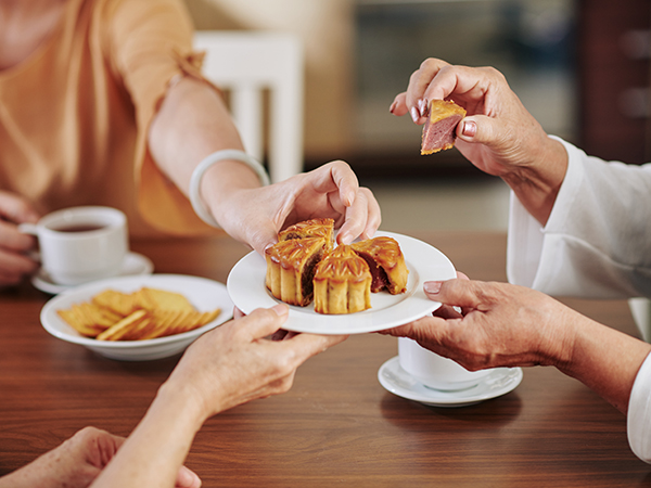 Family and friends enjoy slices of mooncake, a traditional food eaten during the Mid-Autumn Festival celebration.
