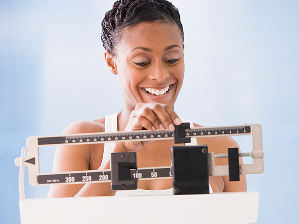 Woman weighing herself - What a Healthy Weight Loss Plan Really Looks Like