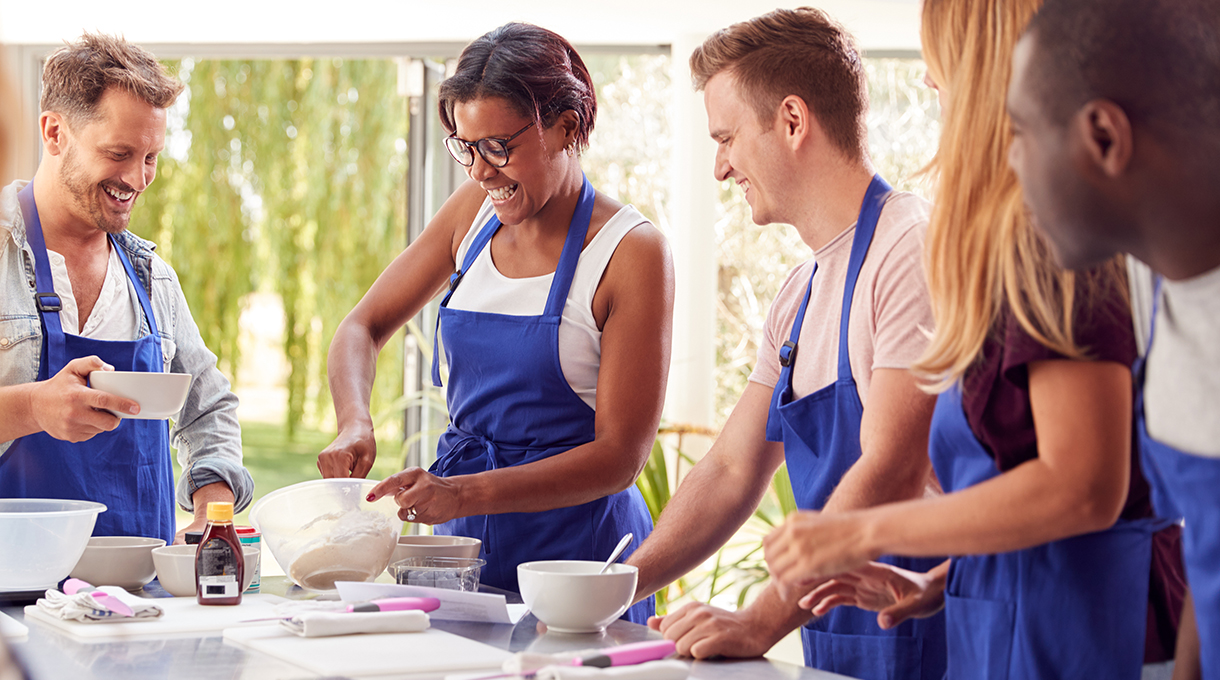 A male food and nutrition professional (RDN or NDTR) is leading a cooking demonstration and hands-on class with teenagers and young adults for Kids Eat Right Month.