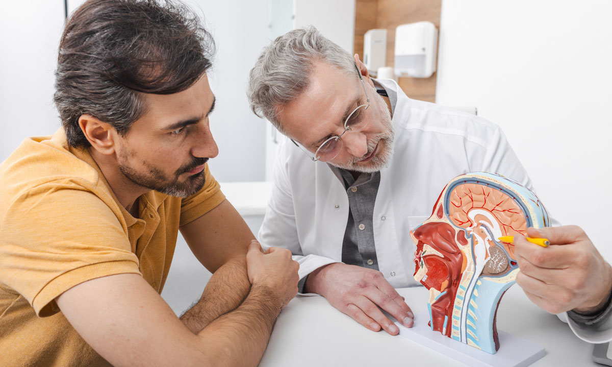 A doctor with his patient, looking at a diagram of the brain.