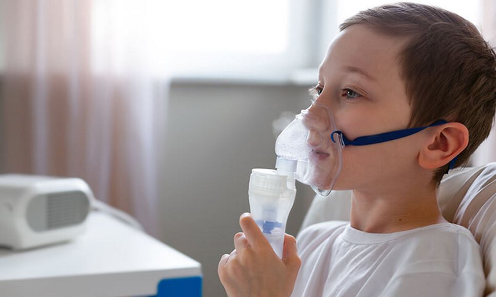 boy using nebulizer/inhaler for cystic fibrosis lung disease