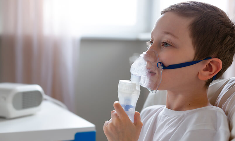 boy using nebulizer/inhaler for cystic fibrosis lung disease