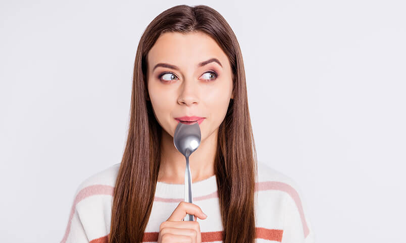 woman holding spoon in her mouth
