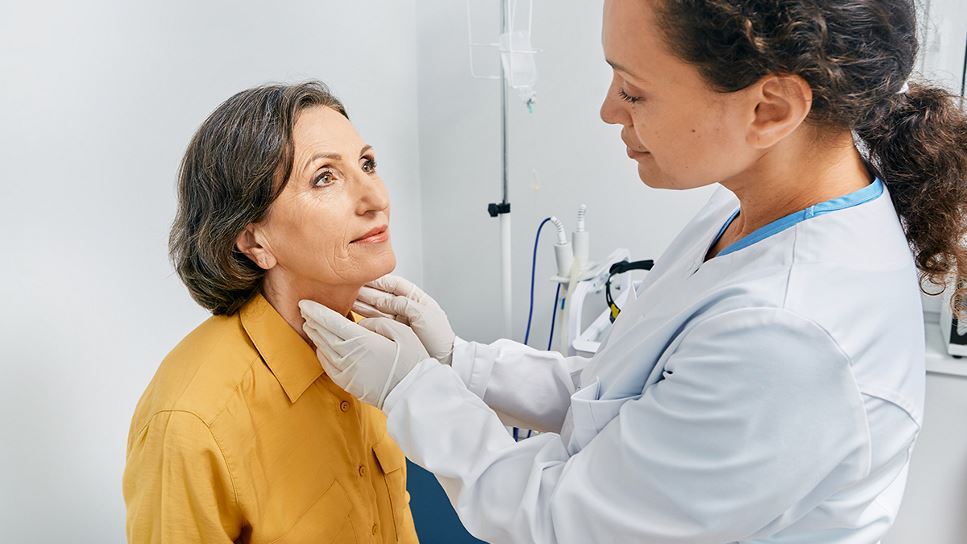 Woman getting a medical examination for hormone issues such as thyroid disease, an endocrine disorder.
