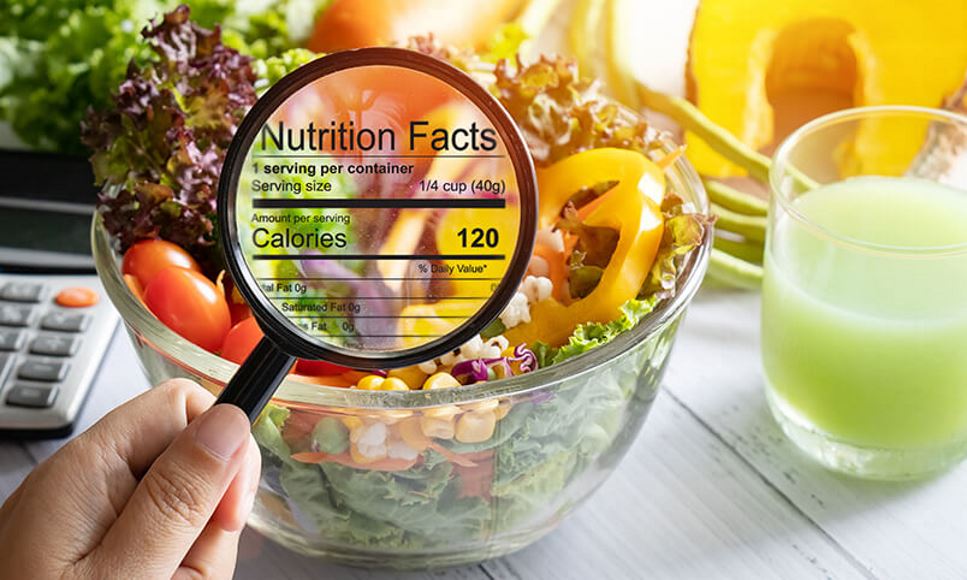 magnifying glass on salad with Nutrition Facts panel