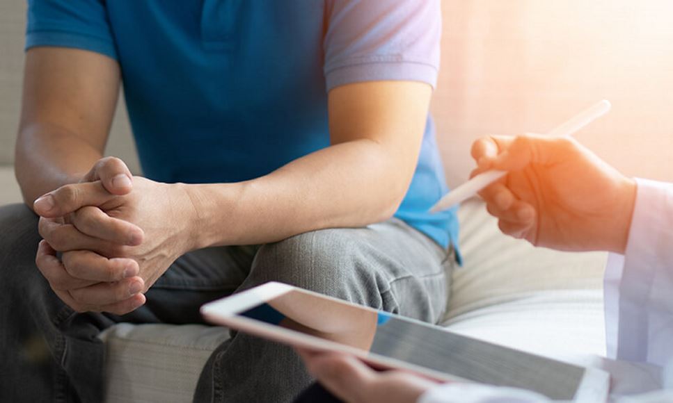 man sitting with health care professional getting diagnosis