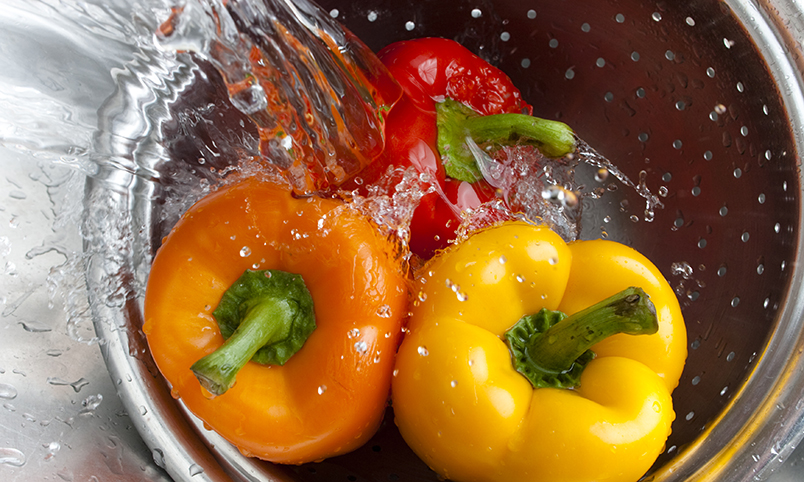 rinsing bell peppers in sink with water
