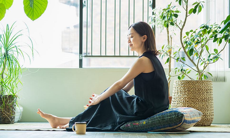 woman sitting on floor with pillow and coffee relaxing