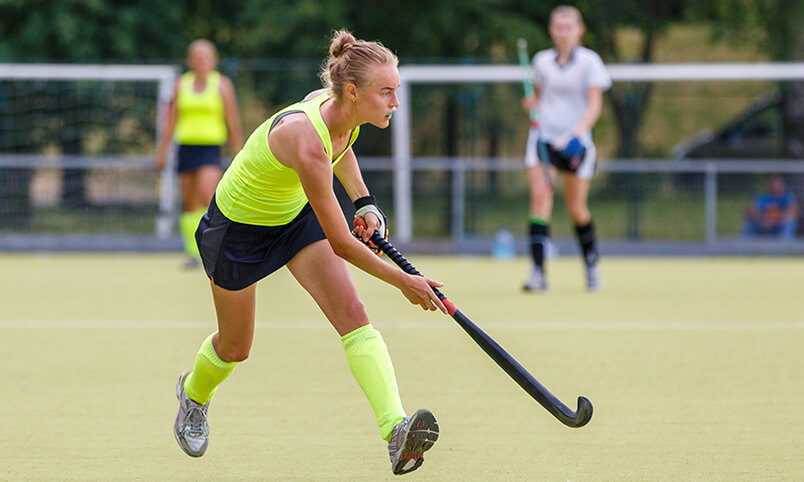 girl playing competitive field hockey
