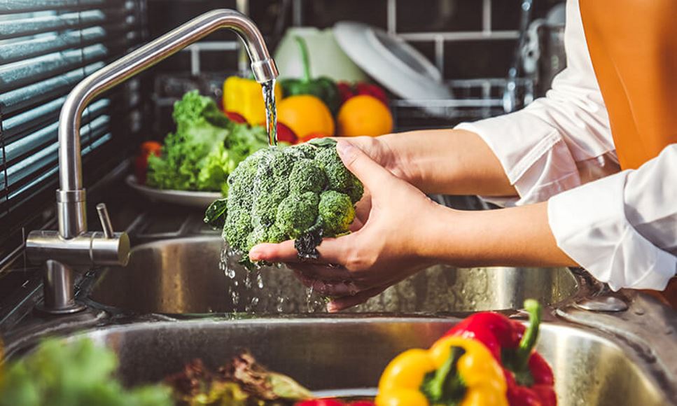 washing vegetables in sink