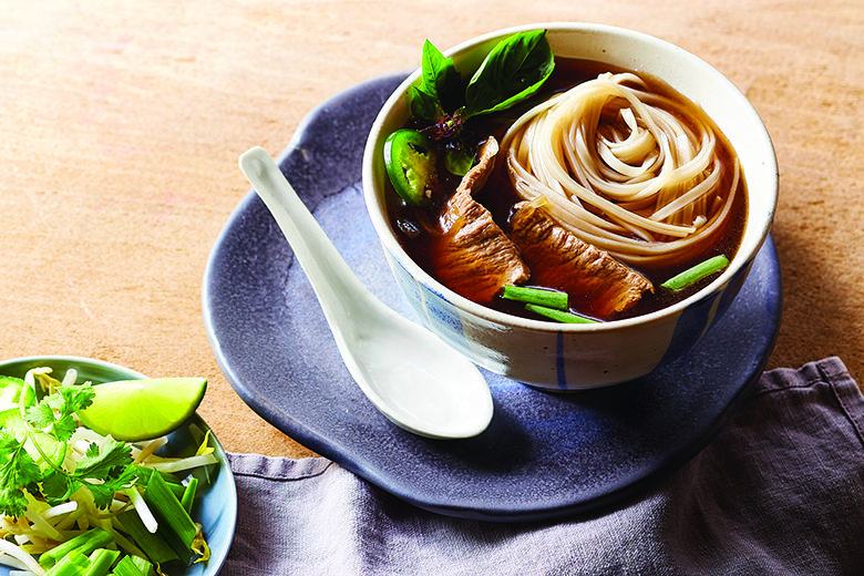 Bowl of beef pho with soup spoon