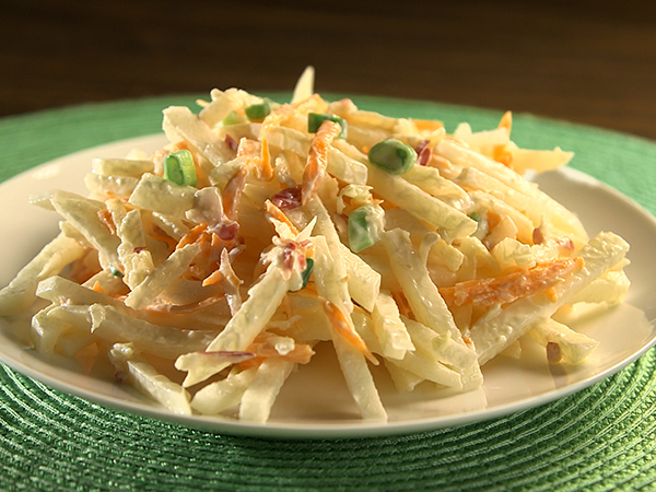 Jicama Apple Slaw A white plate containing creamy jicama apple slaw sitting on a green placemat